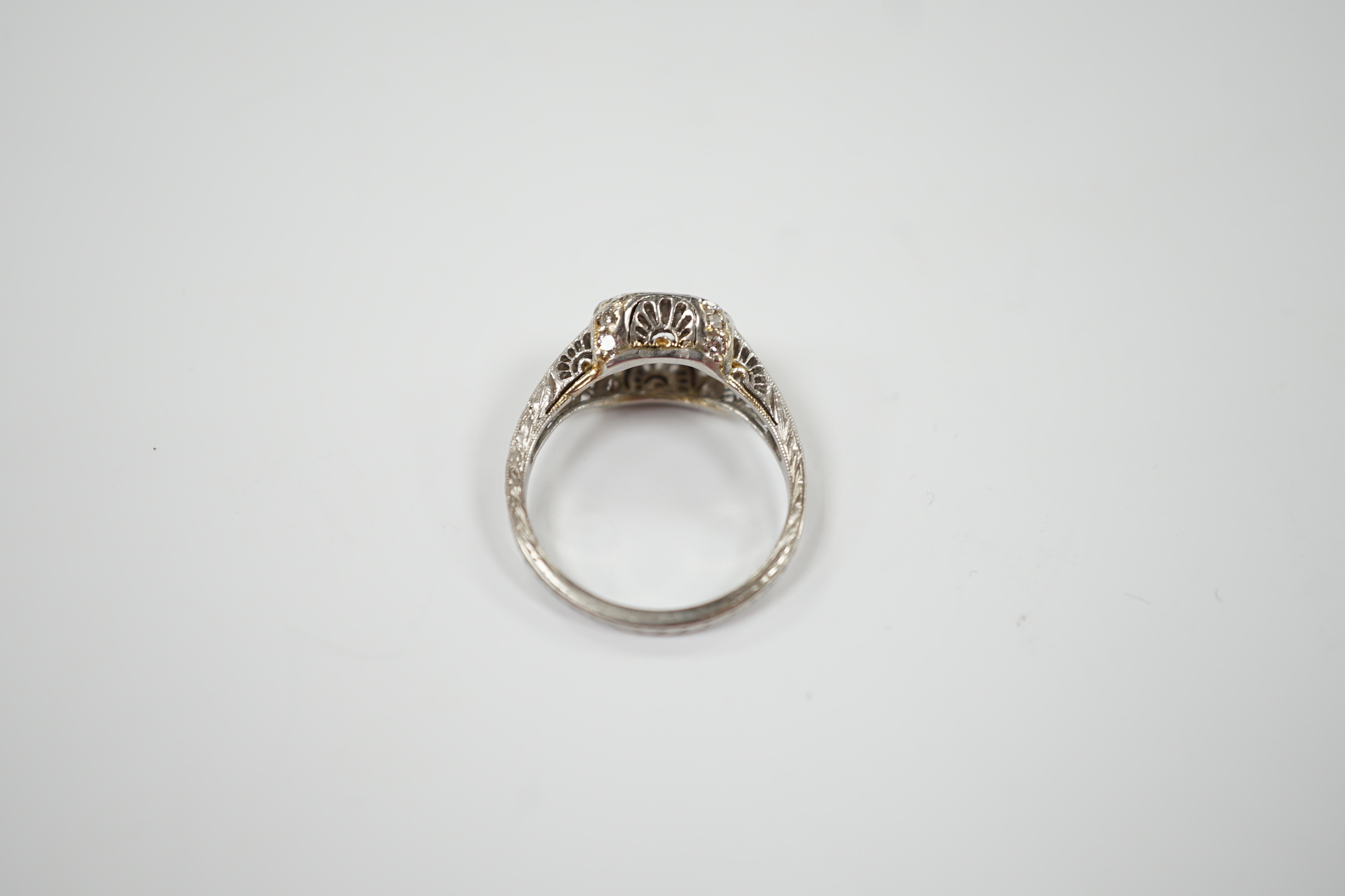 A mid 20th century engraved white metal and single stone diamond set ring, the pierced setting set with twenty small brilliants, size M, gross weight 4.3 grams